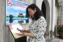 Турист сканирует QR-код, чтобы получить доступ к цифровому экскурсионному маршруту в историческом комплексе храма До. Фото: ВИА