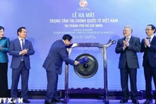 Премьер-министр Фам Минь Тьинь бьёт в гонг, открывая МФЦ в Хошимине. Фото: ВИА