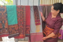 Госпожа Неанг Чань Ти, руководитель кооператива по ткачеству парчи народности Кхмер Ванзяо (община Анкы, провинция Анзянг), представляет уникальные изделия ремесленной деревни. Фото: dantocmiennui.baotintuc.vn