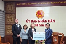 Генеральный консул США в г. Хошимине Мелисса Энн Браун символически вручает пакет помощи заместителю директора Департамента Нгуен Ван Тьену. 