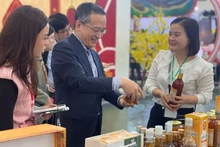 Главный представитель ханойского офиса JETRO Одзаса Харухико (в центре) посещает один из стендов на первой ярмарке «Славная весна» 6 февраля. Фото: ВИА