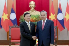 Генеральный секретарь ЦК КПВ То Лам и Генеральный секретарь ЦК НРПЛ, Президент Лаоса Тхонглун Сисулит на церемонии открытия для подписания Конвенции ООН против киберпреступности, состоявшейся в Ханое. Фото: Данг Кхоа