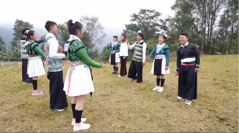 Юноши и девушки играют в бросание «пао».