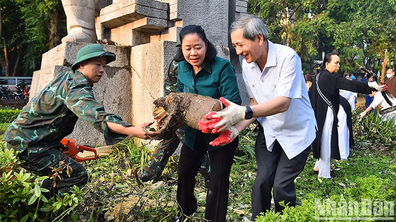 Секретарь Парткома г. Ханоя Буй Тхи Минь Хоай участвует в уборке окружающей среды с жителями города Ханоя.