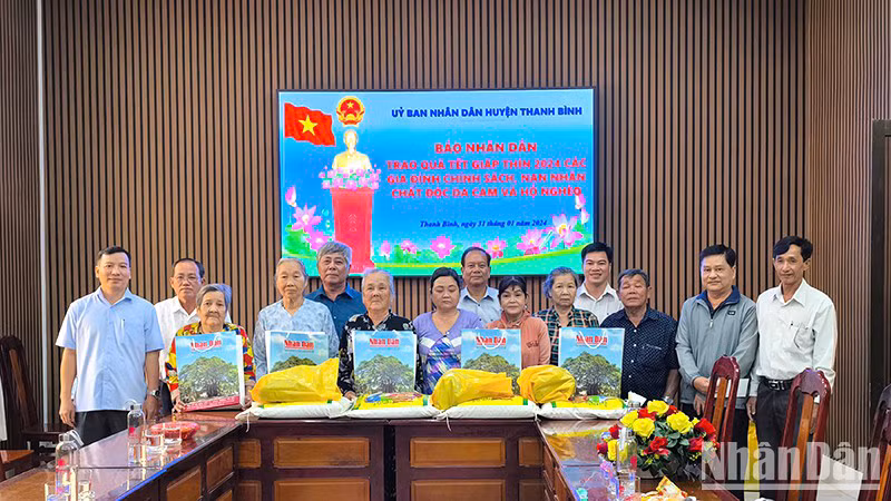 Замначальника Постоянного представительства газеты «Нянзан» в г. Канхо Зыонг Хонг Лам вручает подарки жителями провинции Донгтхап.