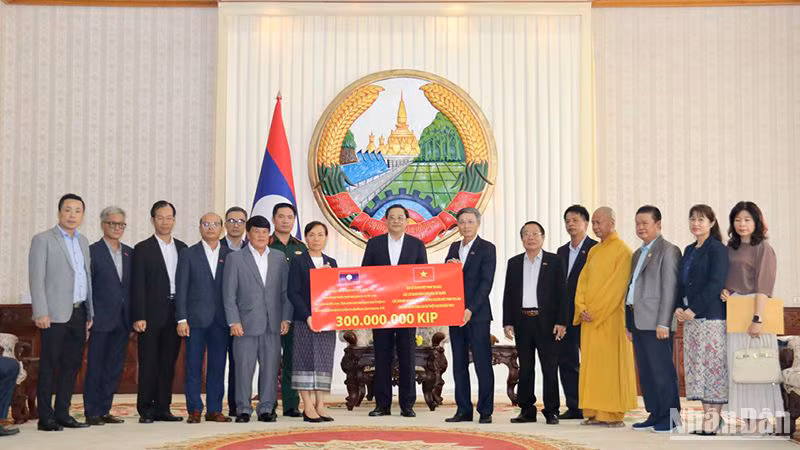 Церемониия вручения средства для поддержки лаосского народа. Фото: Хай Тиен 