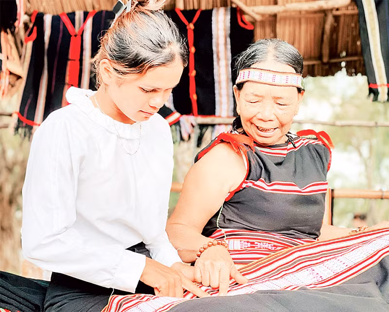 Ремесленник обучает молодежь традиционному ремеслу производства парчи.