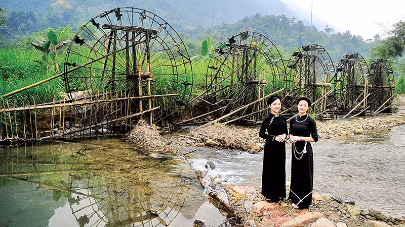 Девушки народности Тэй у водяной мельницы.