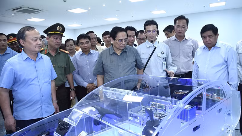 Премьер-министр заслушивает презентацию о продукции компании Mektec Manufacturing Vietnam.