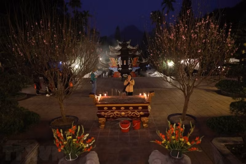 Жители и туристы воскуряют благовония и поклоняются Будде перед открытием фестиваля в пагоде Хыонг.