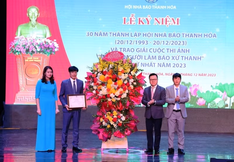 Товарищ Ле Куок Минь вручает Похвальную грамоту Союза журналистов Вьетнама и корзину цветов Ассоциации журналистов провинции Тханьхоа.