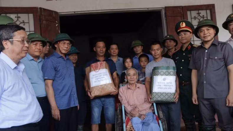 Вице-премьер, Министр иностранных дел Буй Тхань Шон вручает подарки семьям в уезде Чангдинь. Фото: Хунг Чанг - Хоанг Ли