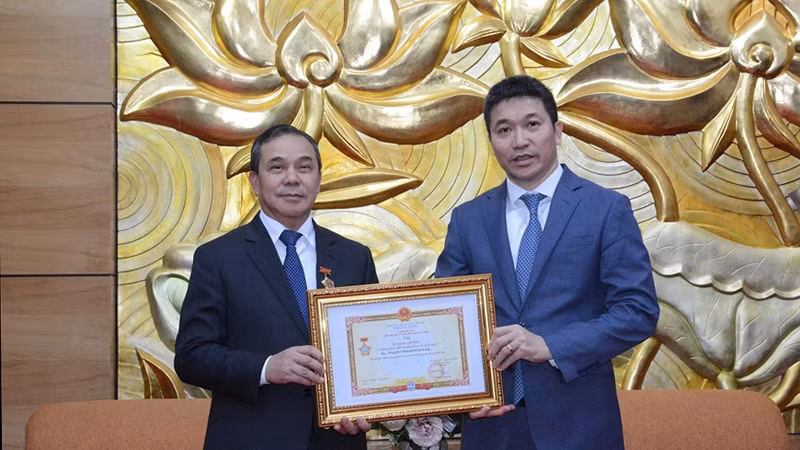 Председатель СОДВ Фан Ань Шон (справа) вручает памятную медаль «За мир и дружбу между народами» Послу Лаоса во Вьетнаме Сенгфет Хоунгбоунгнуангу. Фото: qdnd.vn