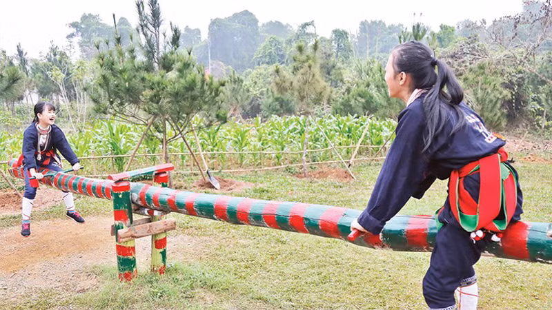 Дети группы Заокуантьет катаются на качелях.
