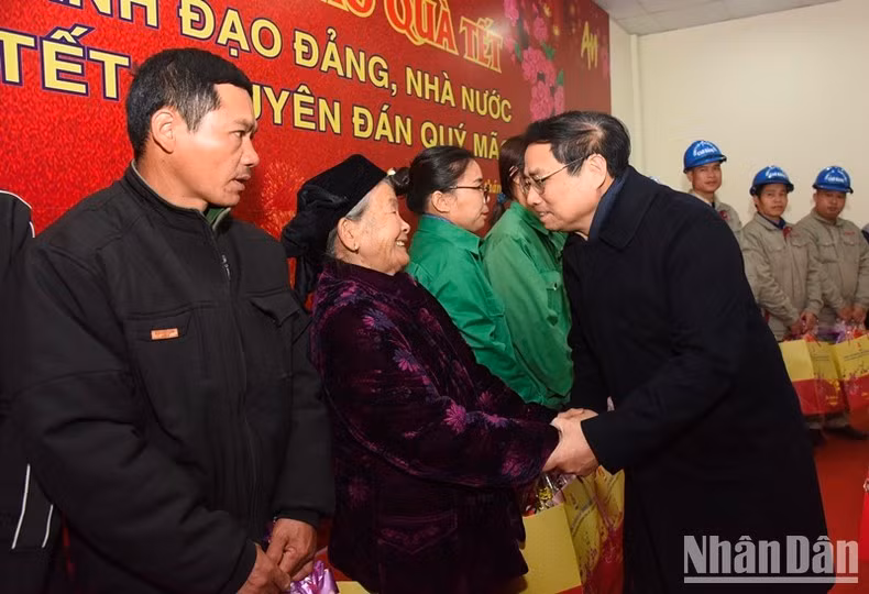 Премьер-министр Фам Минь Тьинь вручает подарки людям, имеющим заслуги перед Родиной, малоимущим в уезде Куангхоа.