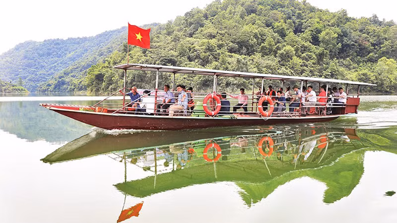 Туристы катаются по озеру на лодке.