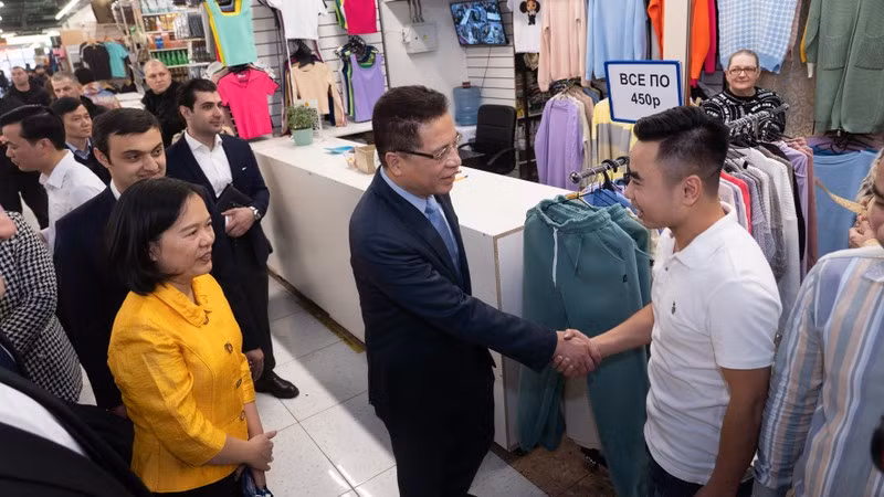 Посол Данг Минь Кхой разговаривает с вьетнамскими торговцами. Фото: Тхань Тхэ