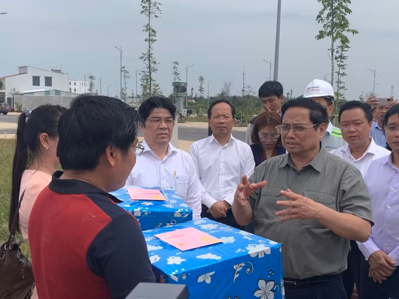 Премьер-министр Фам Минь Тьинь вручает подарки жителям района переселения в г. Кантхо. Фото: Тхань Там