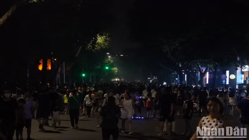 На пешеходной улице Диньтиенхоанг много прохожих несмотря на отсутствие света.