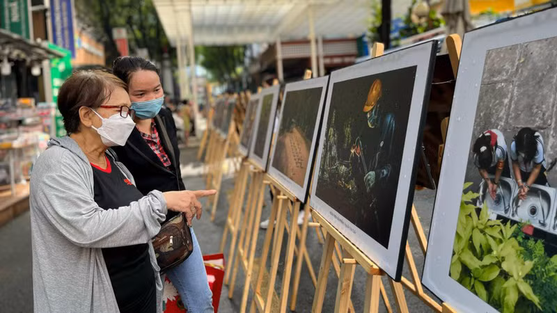 Посетители выставки, устроенной на книжной улице им. Нгуен Ван Биня.