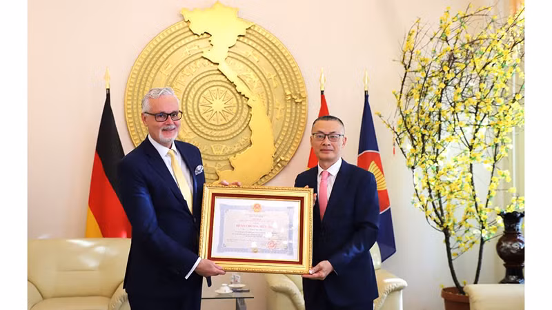 Посол Ву Куанг Минь вручает Орден Дружбы бывшему Послу Германии во Вьетнаме Гвидо Хильднеру. Фото: ВИА