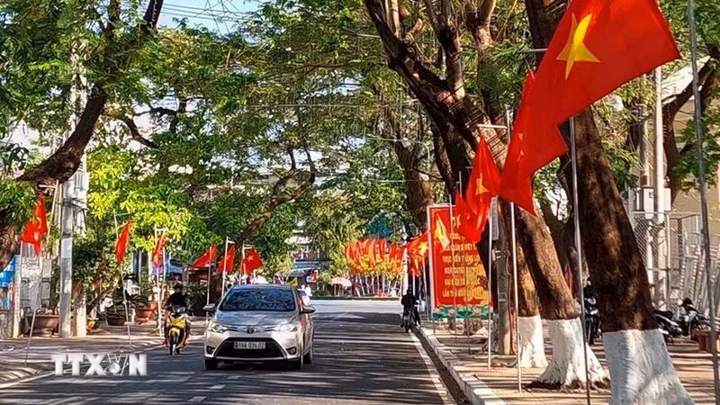 Улица, украшенная флагами и транспарантами, в городе Камау провинции Камау. Праздник Тэт в 2025 году продлится с 25 января по 2 февраля. Фото: ВИA