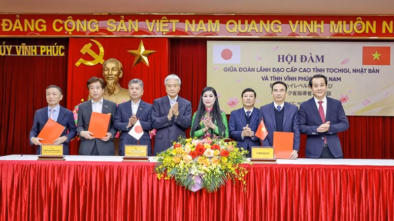 Руководители двух местностей подписывают Соглашение о сотрудничестве по поощрению инвестиций. Фото: Ха Хонг Ха