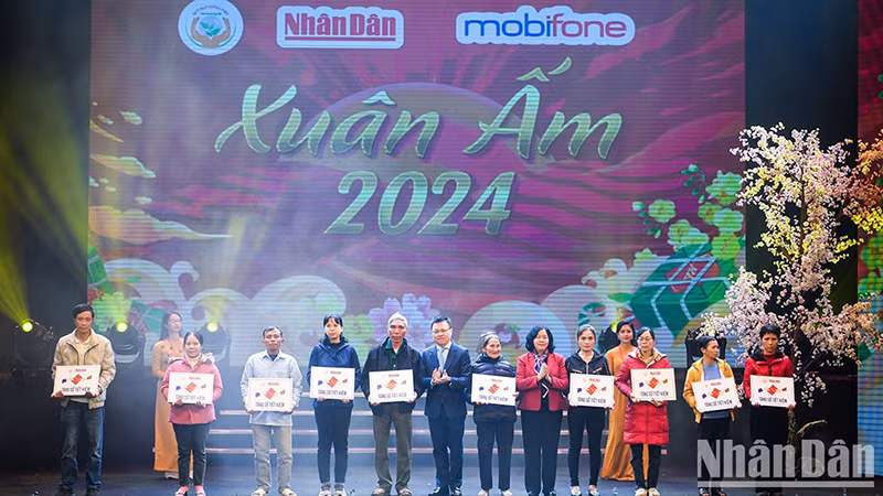 Товарищ Буй Тхи Минь Хоай и товарищ Ле Куок Минь вручают сберегательные книжки малоимущим. 