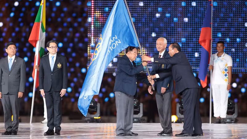 Вице-премьер, Министр обороны Камбоджи Теа Бань в качестве главы оргкомитета SEA Games 32 вручает флаг Спортивной федерации Юго-Восточной Азии г-ну Гонсак Йодмани, начальнику Управления спорта Таиланда, представителю страны-хозяйки SEA Games 33.