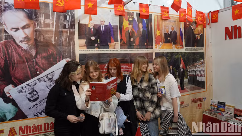 Молодые девушки посещают стенд газеты «Нянзан». Они сказали, что всегда хотят приехать во Вьетнам на отдых.