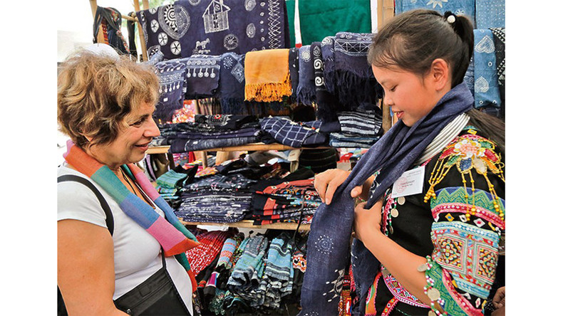 Иностранным туристам нравятся традиционные узоры на ткани, окрашенной индиго. Иностранным туристам нравятся традиционные узоры на ткани, окрашенной индиго.