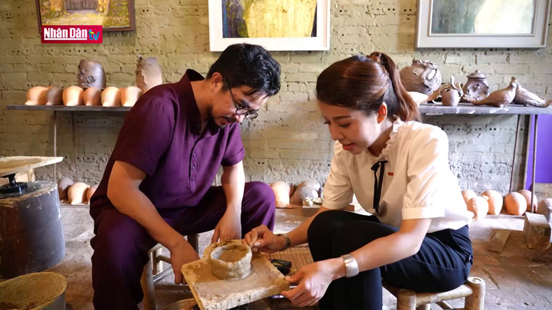 Художник Нгуен Тан Фат (слева) инструктирует туристку по изготовлению гончарных изделий.