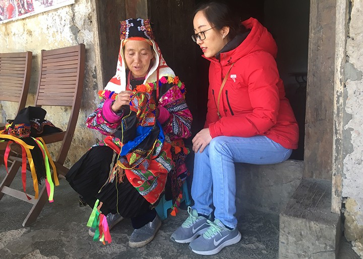 Туристка знакомится с традиционным костюмом представителей народности Лоло. Туристка знакомится с традиционным костюмом представителей народности Лоло.