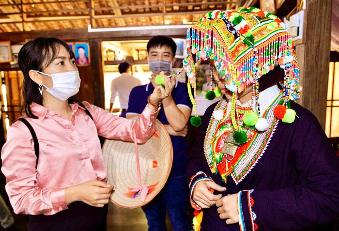 Туристы с интересом наслаждаются красотой красочных костюмов с тонкими узорами у представителей Заолуданг. Туристы с интересом наслаждаются красотой красочных костюмов с тонкими узорами у представителей Заолуданг.