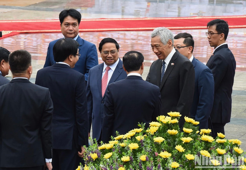 Премьер-министр Фам Минь Тьинь представляет членов вьетнамской делегации Премьер-министру Ли Сяньлуну. Премьер-министр Фам Минь Тьинь представляет членов вьетнамской делегации Премьер-министру Ли Сяньлуну.