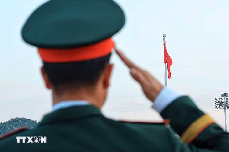 Военнослужащий отдает честь Государственному флагу в момент его поднятия на площади Бадинь. Фото: Фам Туан Ань/ВИА