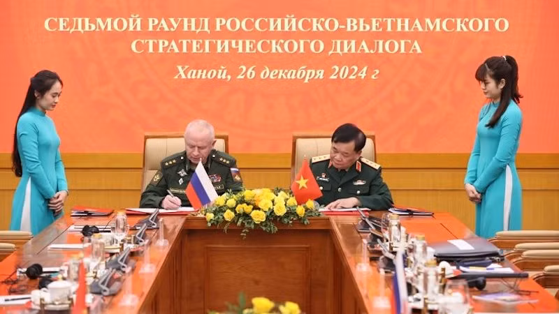 Генерал-полковник Хоанг Суан Тьиен и генерал-полковник Александр Фомин пописывают документы о сотрудничестве.