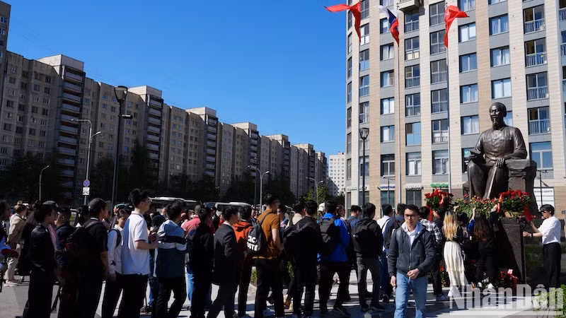 Вьетнамские студенты возгалают цветы к памятнику Президенту Хо Ши Мину. Фото: Суан Хынг