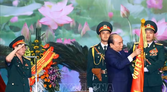 Премьер-министр Нгуен Суан Фук вручает Решение и прикрепляет Орден Защиты Отечества 1-й степени на боевое знамя соединения № 12. Фото: VNA