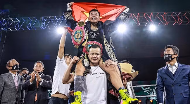 Тху Ньи поднимает вьетнамский флаг. Фото: WBO